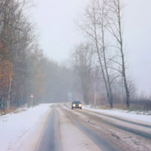 approaching-car-with-headlights-on-in-winter-square